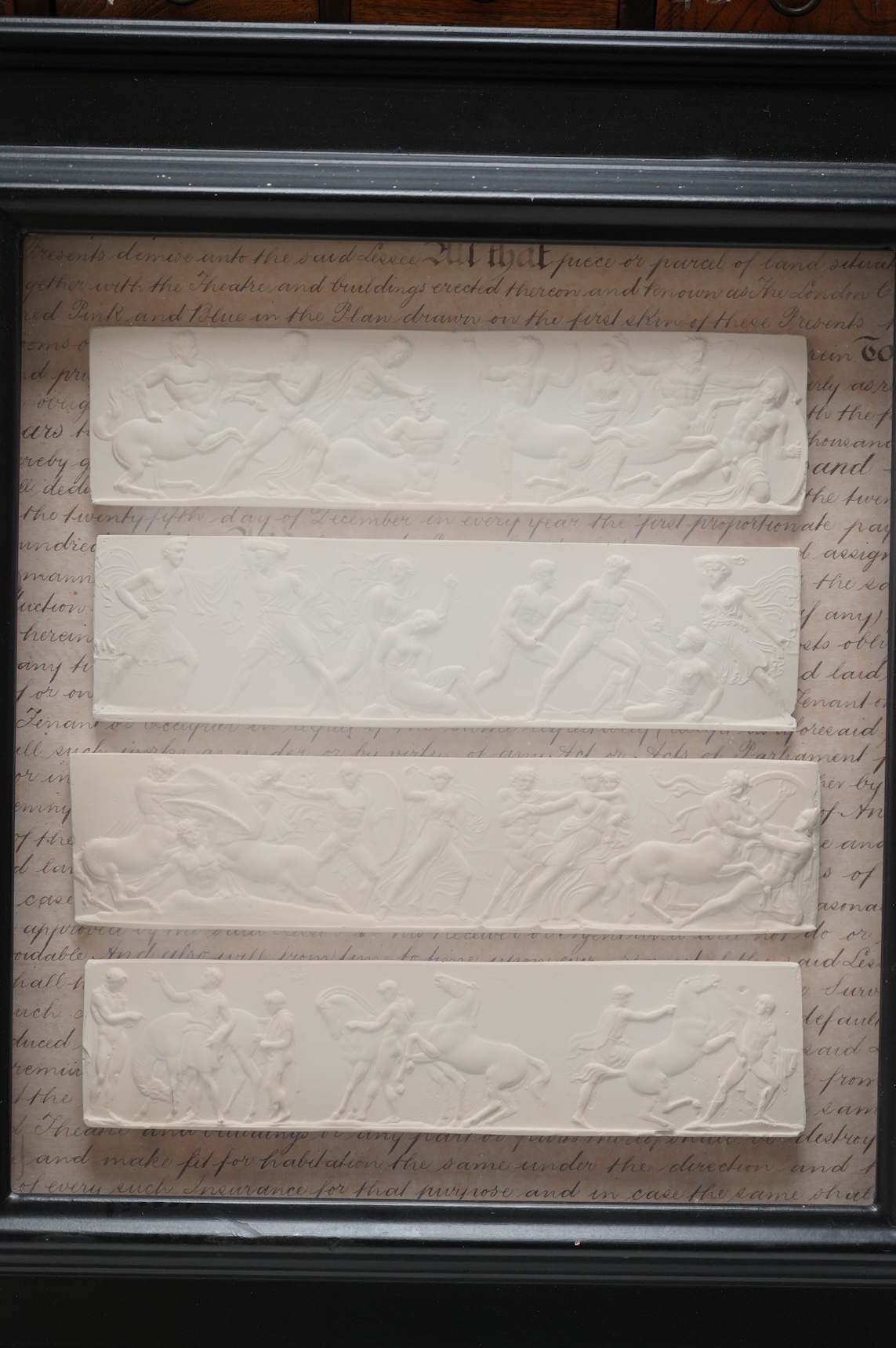 A set of four plaster plaques depicting classical scenes and four 18th/19th century architectural etchings, framed, largest 43cm high